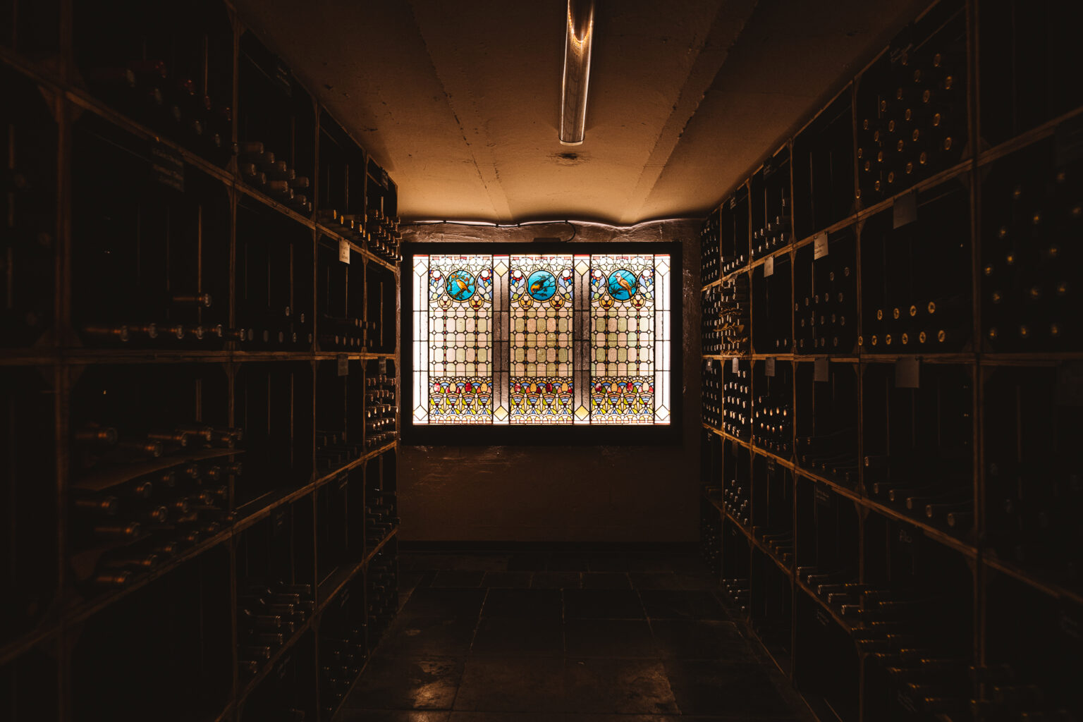 Wijnkelder van Harry’s met wijnrekken en glas-in-lood